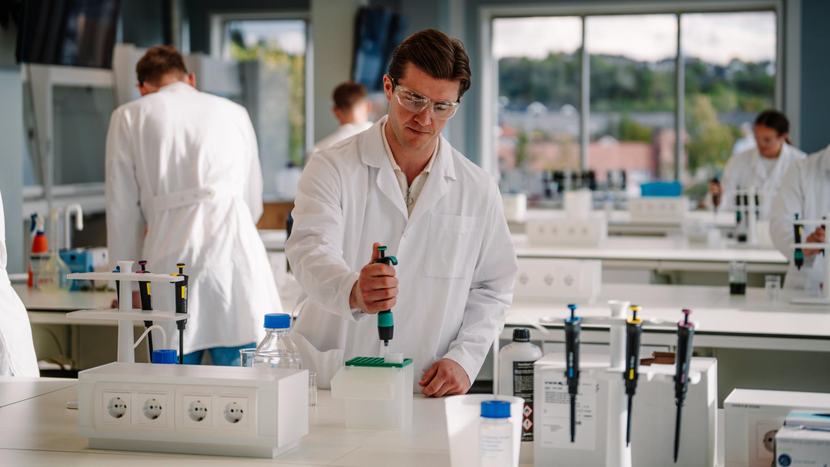 Mannlig forsker som står å pippeterer inne på laboratoriet